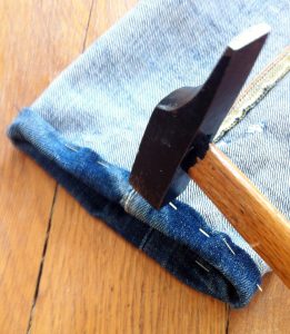 Le marteau qui va aider à coudre l'ourlet du jeans.